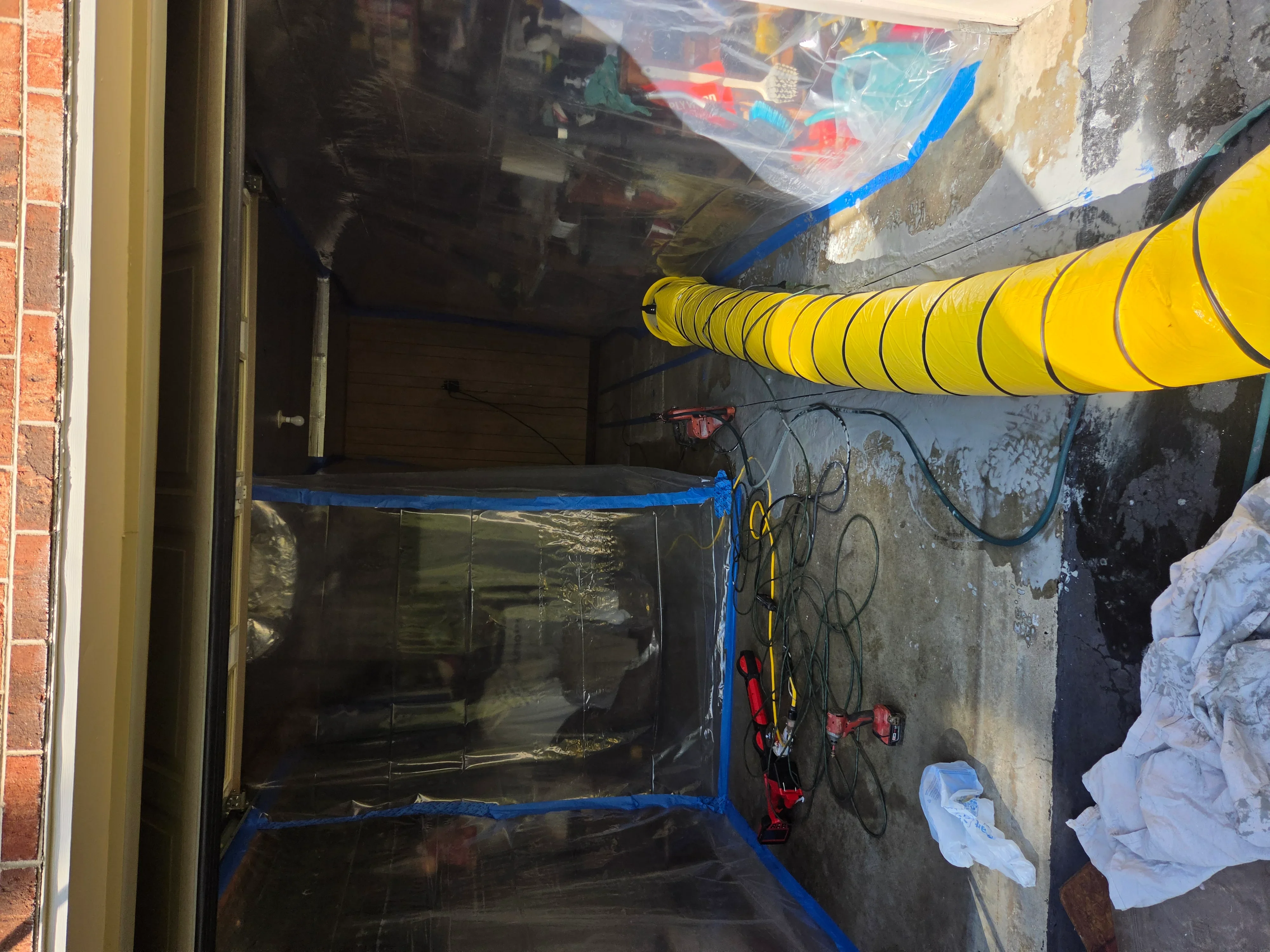 Industrial yellow drying equipment and blue containment barriers in basement water damage mitigation